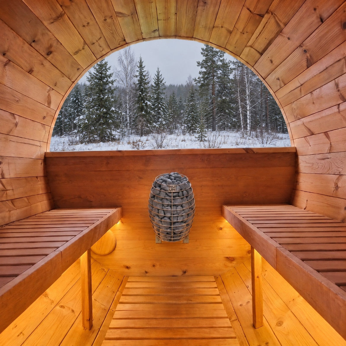 Fasssauna innen mit HUUM Drop Elektroofen an der Wand und Blick in den verschneiten Wald